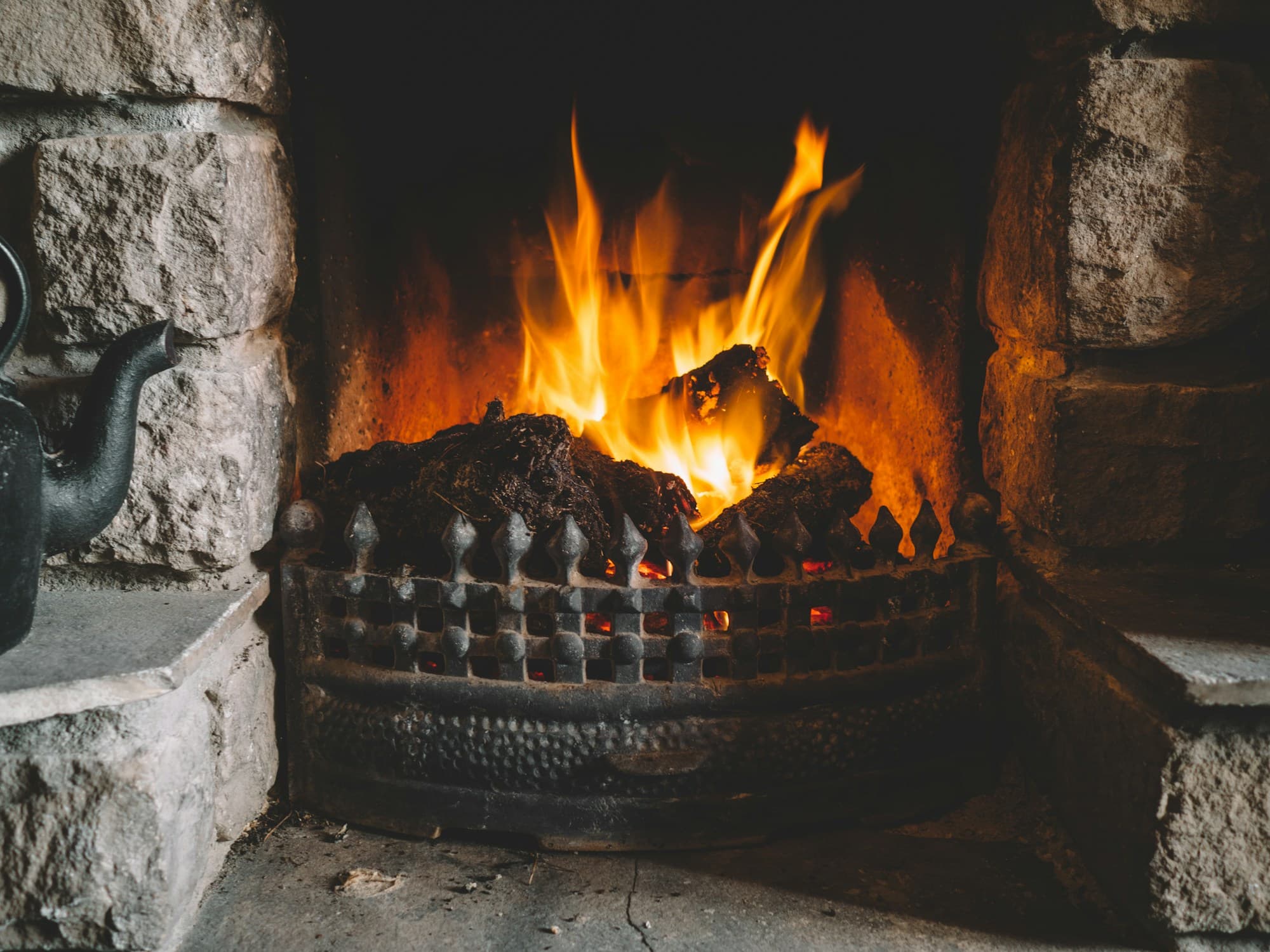 An inviting fire in a traditional Irish stone fireplace